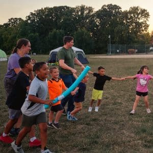 YMCA Family Campout participants enjoy outdoor games together on a grassy field near tents at the Hendricks Regional Health YMCA.