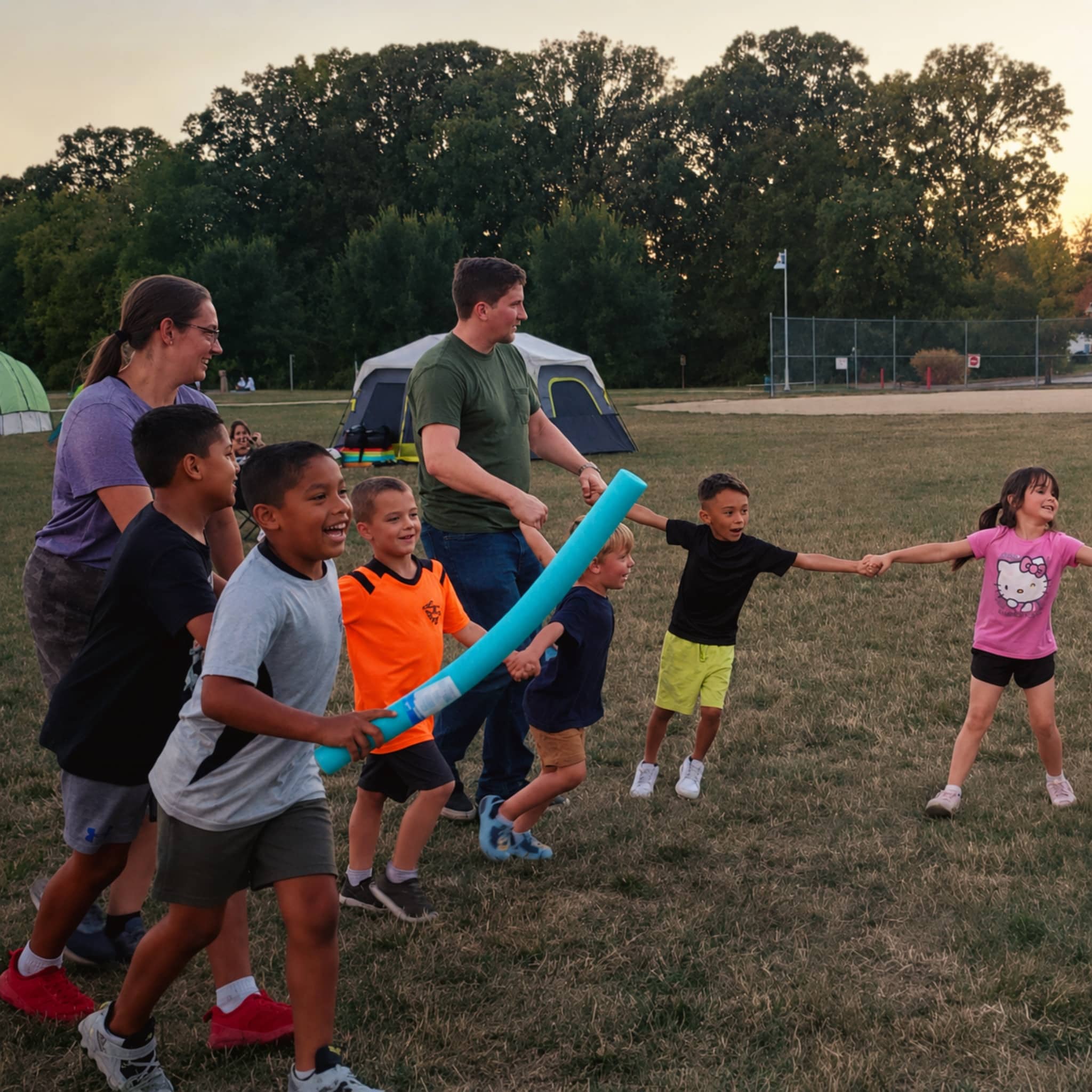 YMCA Family Campout participants enjoy outdoor games together on a grassy field near tents at the Hendricks Regional Health YMCA.