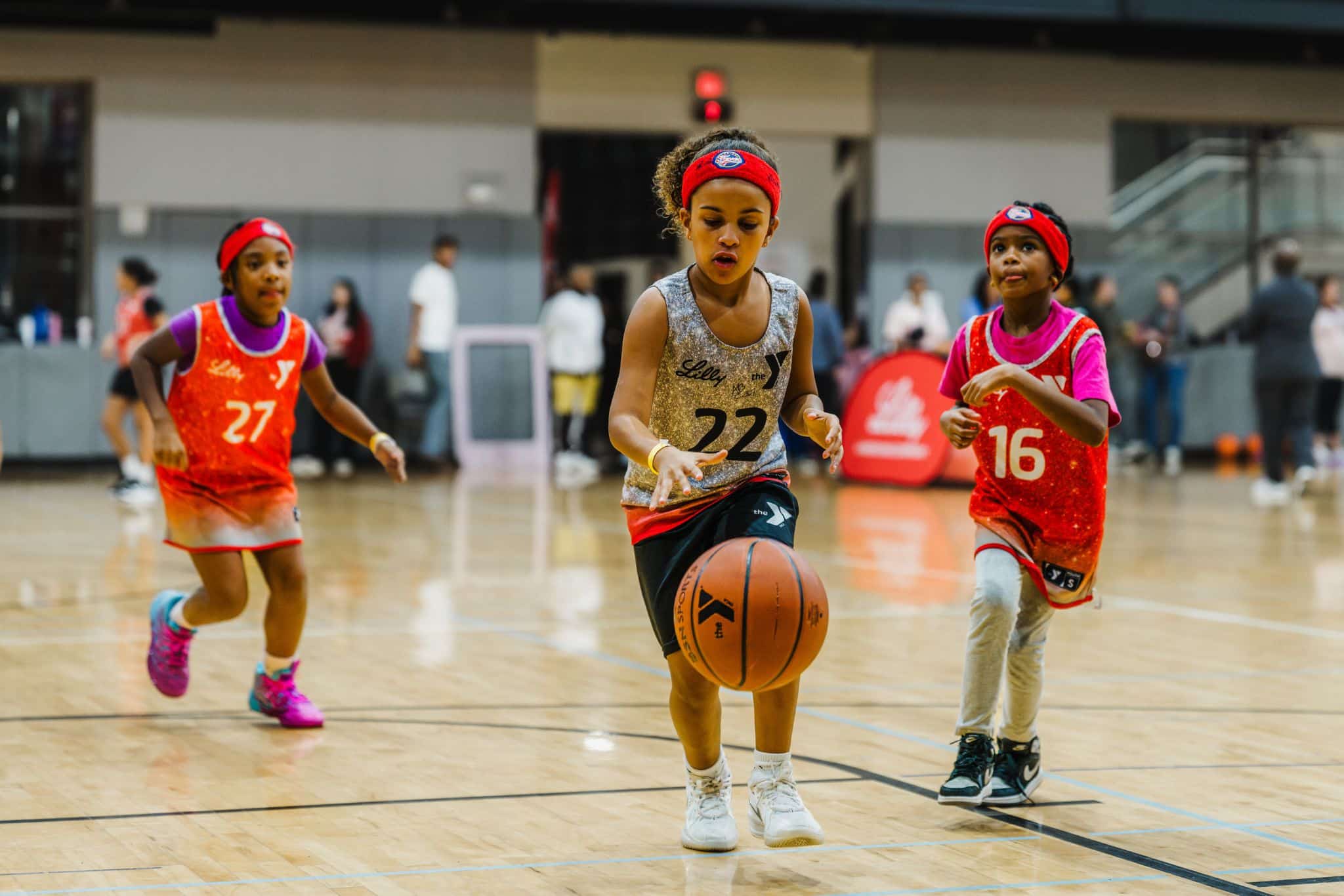 Girls playing basketball driving ball past defender