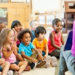 A group of children listening to a storybook being read
