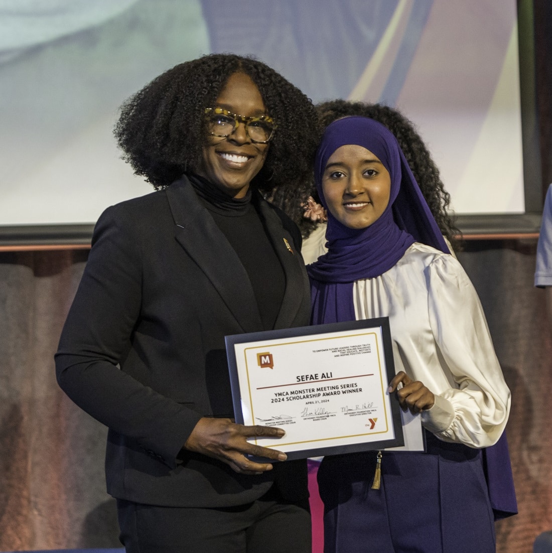 A Monster Meeting scholarship recipient receives her certificate.