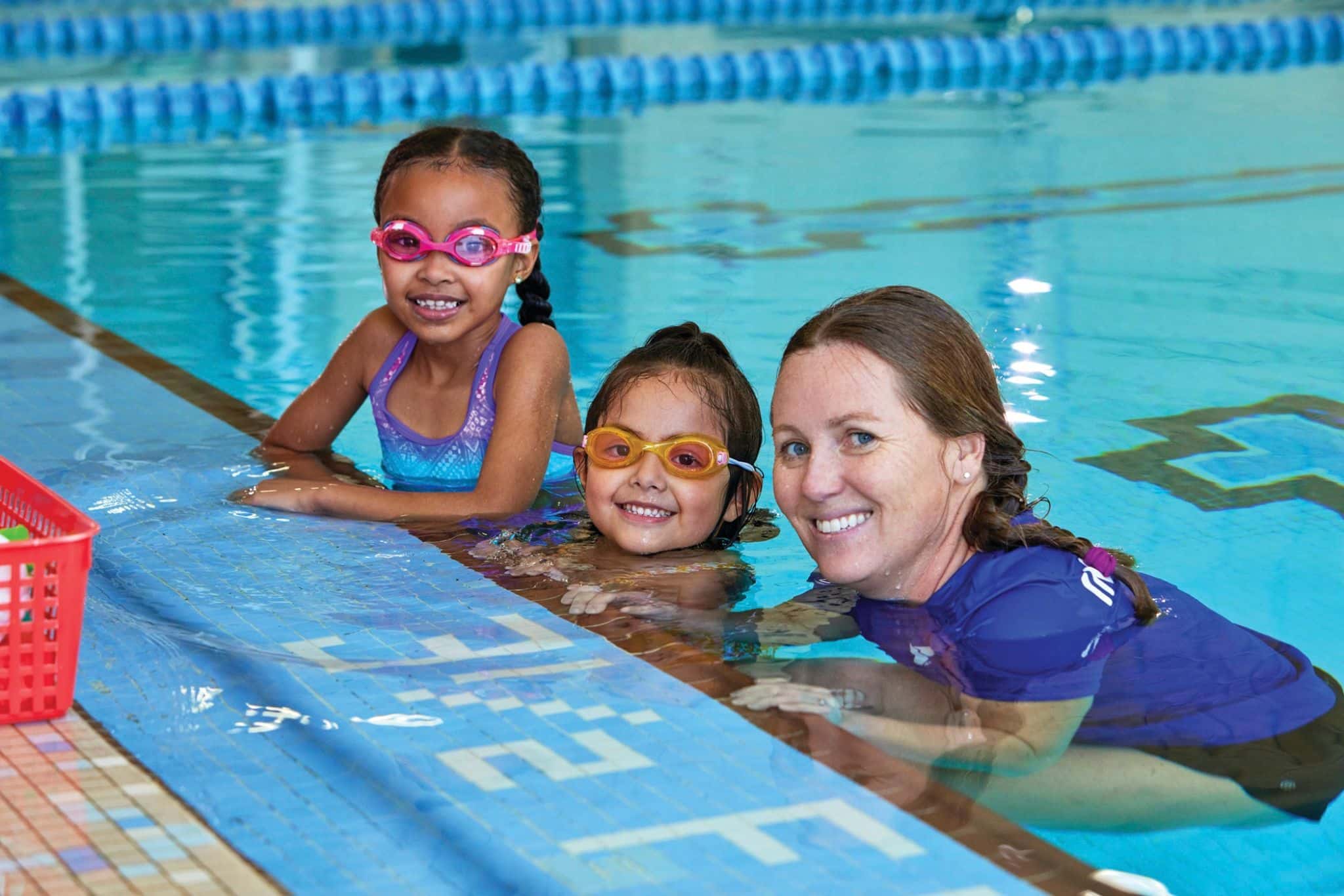 Students smile during a YMCA swim lesson.