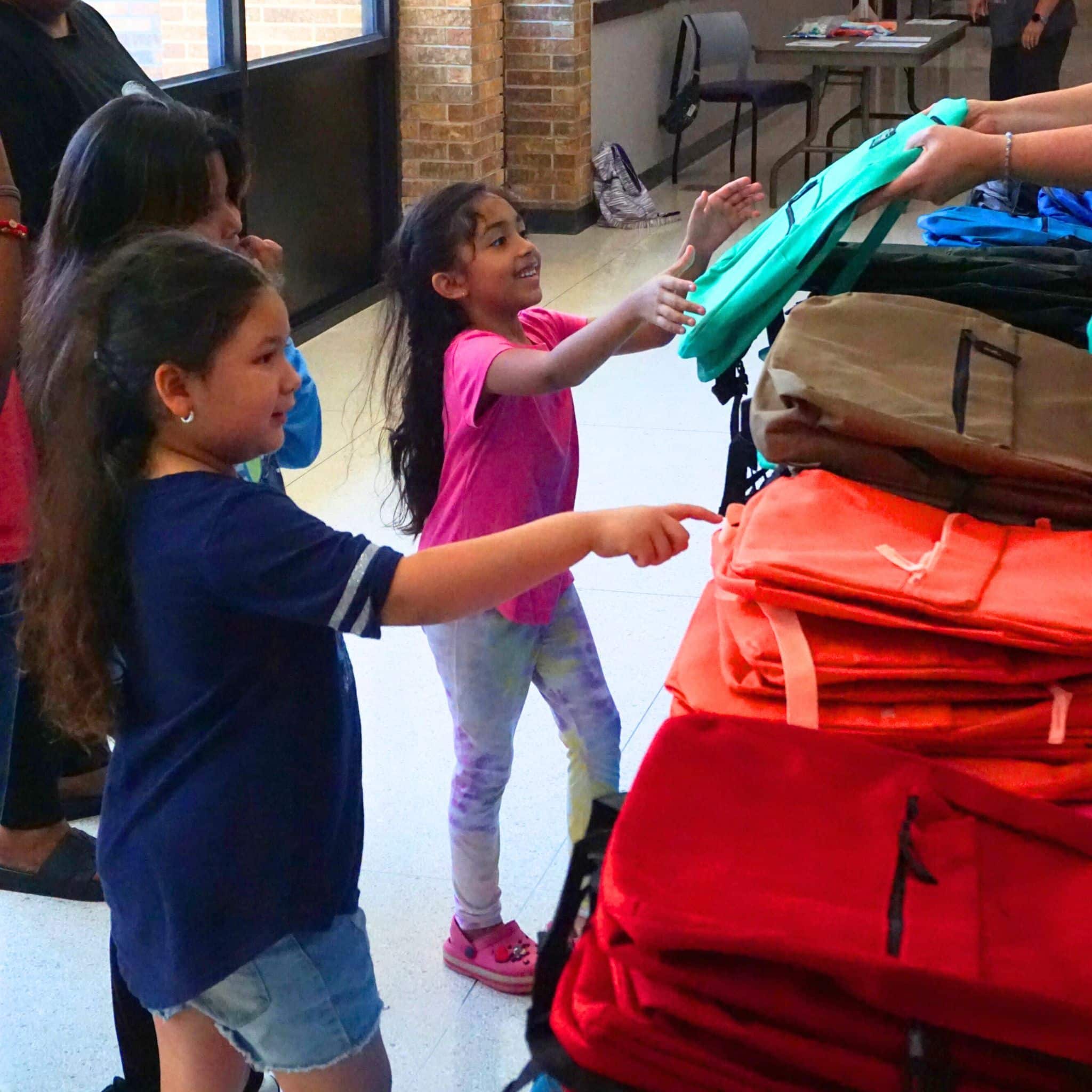 Elementary students receive colorful backpacks and school supplies during the Hendricks Regional Health YMCA Back to School Fest.