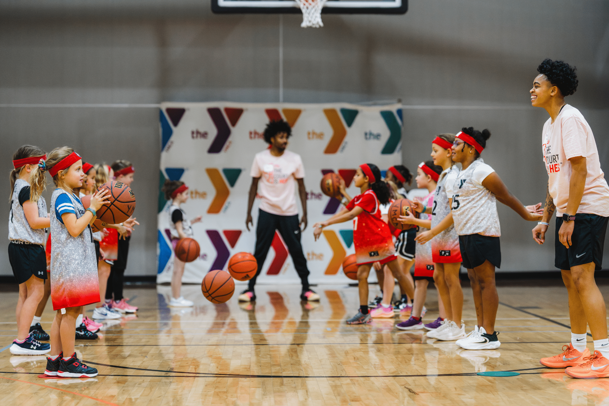 Girls learn basketball skills at a clinic.