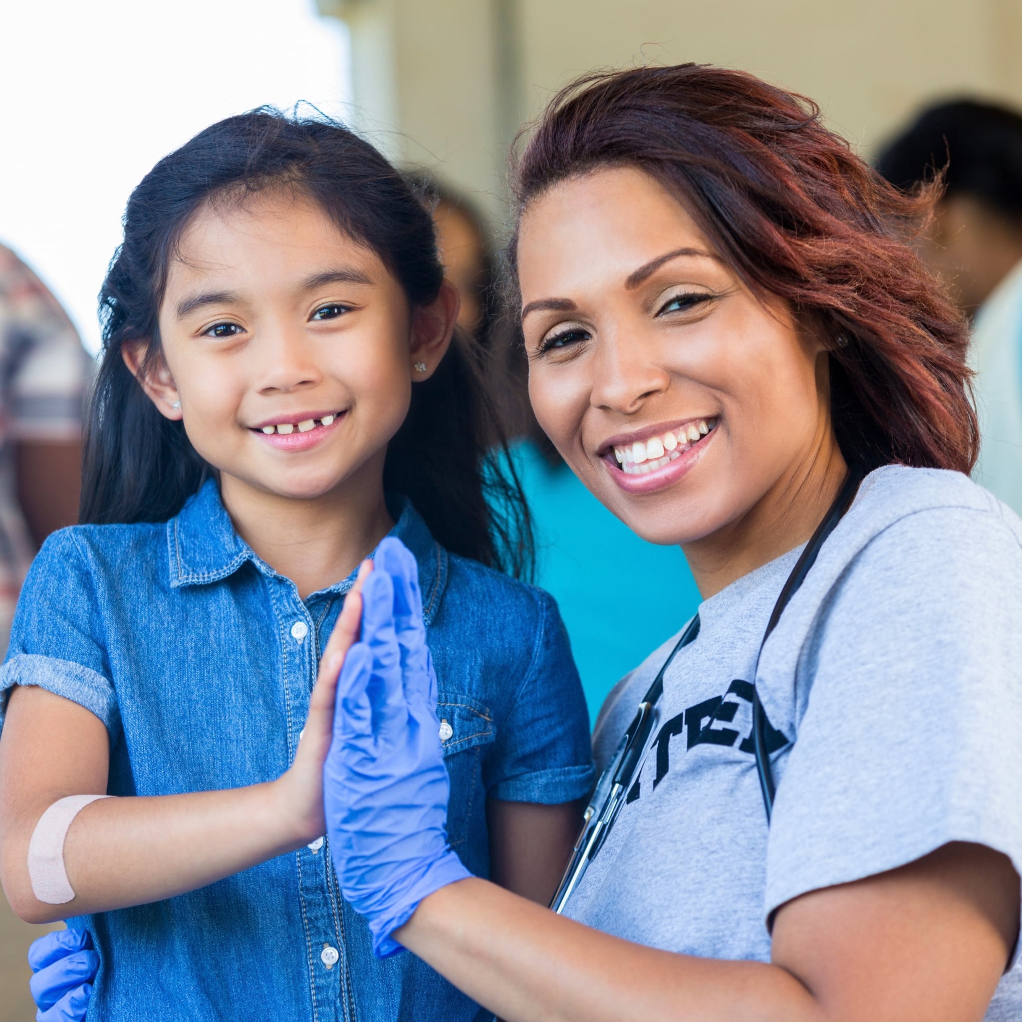 Smiling healthcare worker with a young girl at the Ascension St. Vincent YMCA in Westfield Community Health Fair.